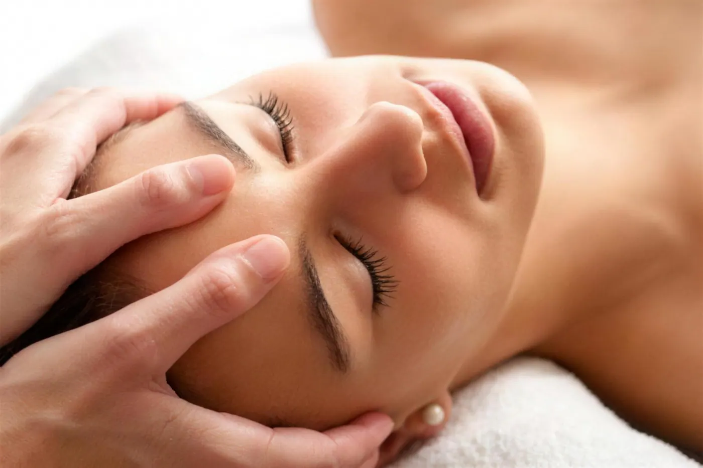 A client resting with eyes closed while a practitioner cradles their head.