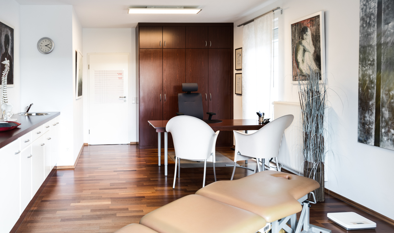 "Modern osteopathy clinic interior with treatment table and comfortable seating area"